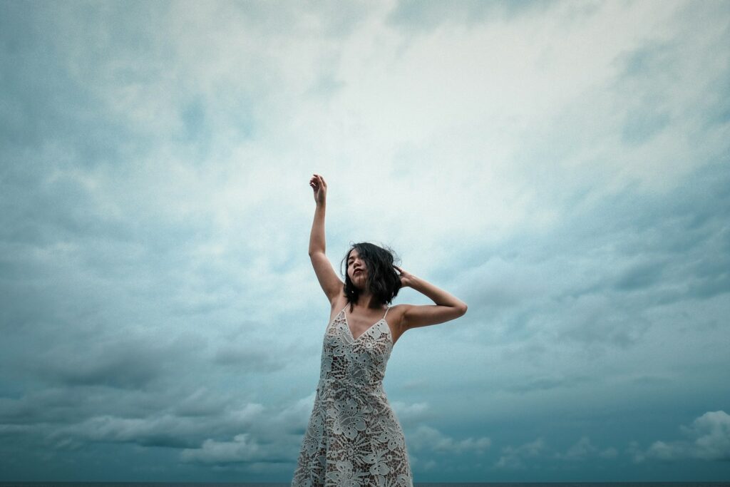 woman wearing white floral dress raising right hand in Maldives